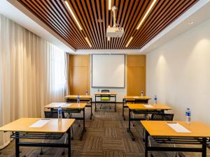 a classroom with wooden tables and a whiteboard at Holiday Inn Express Litang by IHG in Lithang