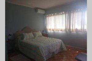 a bedroom with a bed and a window at Edificio Céntrico. in Colonia del Sacramento