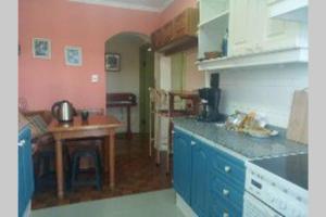 a kitchen with blue cabinets and a table in it at Edificio Céntrico. in Colonia del Sacramento