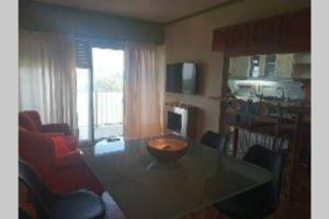a living room with a dining room table with chairs at Edificio Céntrico. in Colonia del Sacramento
