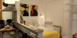 Habitación con cama amarilla, escritorio y algunas pinturas. en Casa Eladia en Logroño