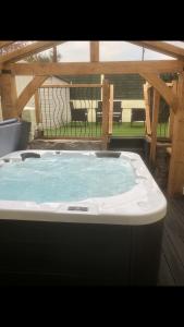 a large hot tub sitting on a deck with a patio at Rhos St Retreat in Ruthin