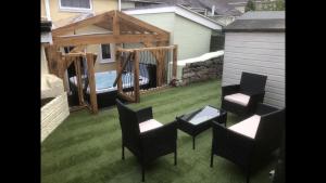 a backyard with chairs and a gazebo and a deck at Rhos St Retreat in Ruthin