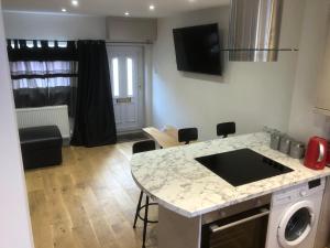 a kitchen and living room with a counter and a table at Rhos St Retreat in Ruthin