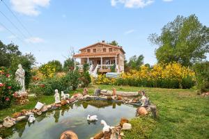 a house with a pond in front of a yard at 3 bedrooms villa with city view private pool and jacuzzi at Porzuna in Porzuna