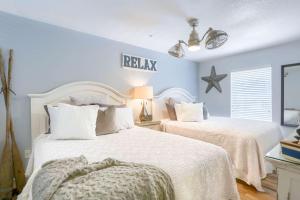 two beds in a bedroom with blue walls at 101 Casa de Playa in Clearwater Beach