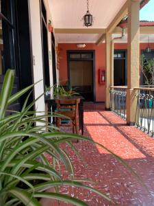 une terrasse couverte d'un bâtiment avec une table et des chaises dans l'établissement Casa Elizabeth, à Quetzaltenango