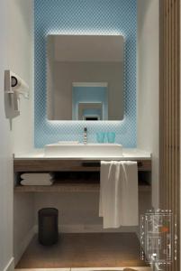 een badkamer met een wastafel en een spiegel bij Holiday Inn Express Jiuzhaigou, an IHG Hotel in Jiuzhaigou
