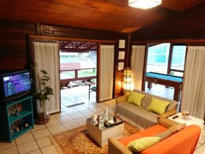 sala de estar con sofá y TV en Willy's Holiday Home, en Florianópolis