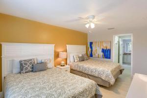 a bedroom with two beds and a ceiling fan at 106 Seagate in Clearwater Beach
