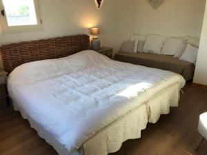 een slaapkamer met een groot wit bed en een raam bij Lush Holiday Home with Private Pool in Pougnadoresse