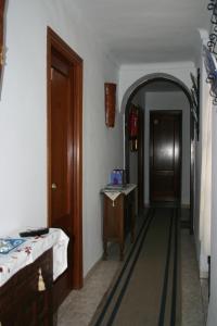 pasillo con arco y puerta de madera en Pension el Portillo, en Córdoba