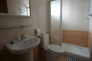 Un baño con inodoro, lavabo y ducha. en Pension el Portillo, en Córdoba 33 fotos más