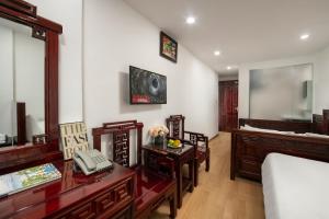 1 dormitorio con 1 cama y escritorio con teléfono en Little Hanoi Hotel, en Hanói