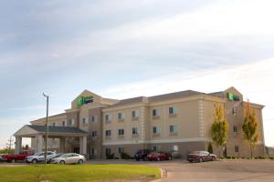 Holiday Inn Express Devils Lake, an IHG Hotel في ديفيلز ليك: فندق فيه سيارات متوقفة في مواقف