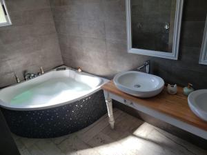 y baño con bañera grande y lavamanos. en Al Nair Casa de playa RESERVA CON SEÑA, en La Pedrera