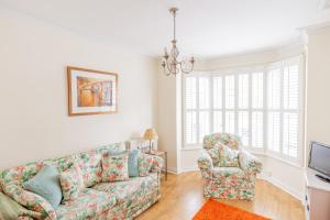 sala de estar con sofá y silla en Strayside Cottage Harrogate - cosy dog friendly cottage sleeps 4. 5 mins walk to hospital and 15 mins walk to town centre en Harrogate