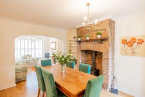 a dining room with a brick fireplace and a wooden table and chairs at Strayside Cottage Harrogate - cosy dog friendly cottage sleeps 4. 5 mins walk to hospital and 15 mins walk to town centre in Harrogate