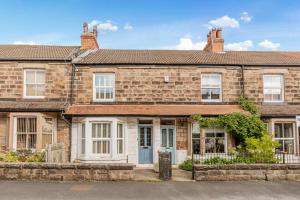 an old brick house with a blue door at Strayside Cottage Harrogate - cosy dog friendly cottage sleeps 4. 5 mins walk to hospital and 15 mins walk to town centre in Harrogate