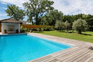 una piscina con terraza de madera junto a un patio en Best Western Plus Le Lavarin, en Aviñón