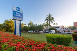 a best western sign in a park with flowers at Best Western Jaco Beach All Inclusive Resort in Jacó