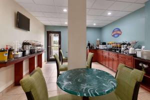 a restaurant with a table and chairs and a kitchen at Baymont by Wyndham Grovetown Augusta in Augusta