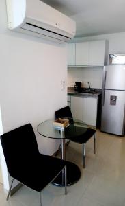 a kitchen with a table and two chairs and a refrigerator at AMOBLADOS MCCORMICK in Bucaramanga