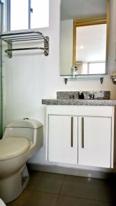 ein Badezimmer mit einem WC, einem Waschbecken und einem Spiegel in der Unterkunft AMOBLADOS MCCORMICK in Bucaramanga