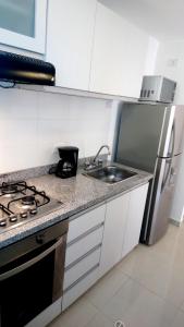 a kitchen with a sink and a stove at AMOBLADOS MCCORMICK in Bucaramanga