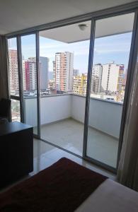 een slaapkamer met een groot raam met uitzicht op de stad bij AMOBLADOS MCCORMICK in Bucaramanga