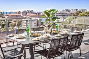 - une table sur un balcon avec de la nourriture et des boissons dans l'établissement Argo Apartments, à Wollongong