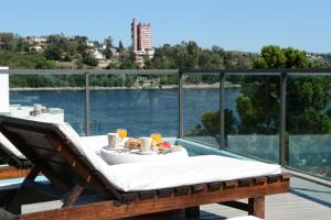 a table on a deck with a view of the water at Costalago Suites- By HVH in Villa Carlos Paz