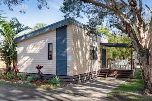 a small white tiny house with a tree at Discovery Parks - Emerald Beach in Emerald Beach