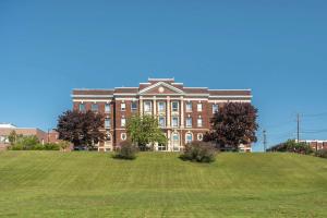 a large brick building on top of a grassy hill at The Courthouse Hotel, Ascend Hotel Collection in Thunder Bay