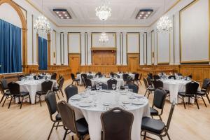 a banquet hall with tables and chairs and chandeliers at The Courthouse Hotel, Ascend Hotel Collection in Thunder Bay