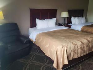 una camera d'albergo con due letti e una sedia di Quality Inn Prattville I-65 a Prattville