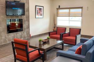 uma sala de estar com um sofá, cadeiras e uma mesa em Comfort Inn em Dawson Creek