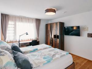 una camera con 2 letti e una TV a schermo piatto di Luxus Neubau 5 min zu Talstation & Caumasee a Flims