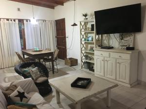 a living room with a tv and a table at Chalet de vacaciones con tu mascota in Necochea