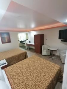 a hotel room with two beds and a table at Hotel Corona Real in Mexico City