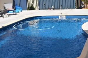 a swimming pool with blue water in a building at Wimmera Motel in Nhill