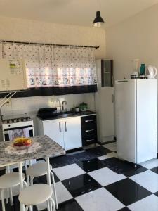 een keuken met een zwart-wit geruite vloer bij Casa Acaraí in São Francisco do Sul