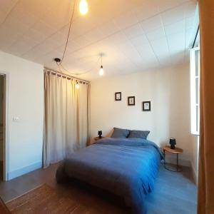 - une chambre avec un grand lit et une fenêtre dans l'établissement Gîte "La Cachette Bourgueilloise", à Bourgueil