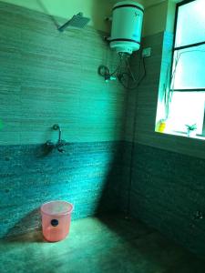 a bathroom with a bucket in the corner with a sink at Tenam Garden homestay in Kalimpong
