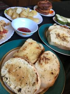 a table with plates of food with bread on them at Tenam Garden homestay in Kalimpong