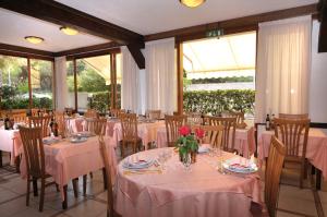 une salle à manger avec tables et chaises et nappes roses dans l'établissement Hotel Lilly, à Marina di Campo