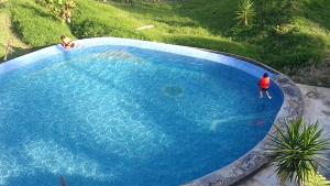 a person is standing in a large blue swimming pool at Hotel Villa Aventura in Cuetzalán del Progreso