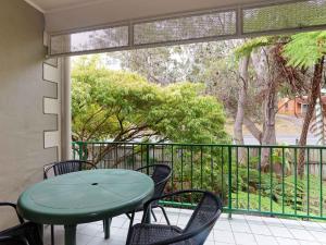 a patio with a table and chairs and a balcony at Carindale, 2 19-23 Dowling Street - First floor unit with air con, complex pool and tennis court in Nelson Bay