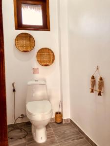 ein Bad mit WC und Korbkörben an der Wand in der Unterkunft Mangata Boutique Bungalows in Srithanu + 37 Fotos