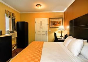 een slaapkamer met een bed en een bureau met een lamp bij The Prince Hotel in Tunkhannock